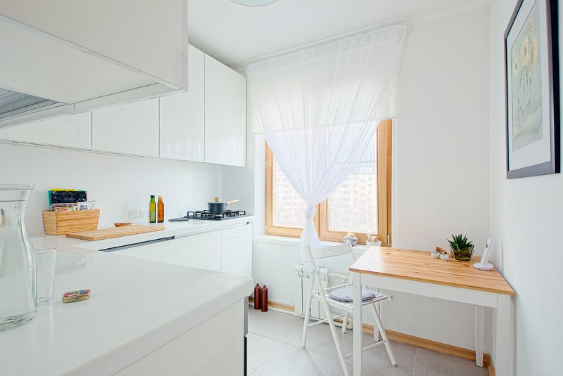 Легкая полупрозрачная занавеска на окне маленькой кухни
