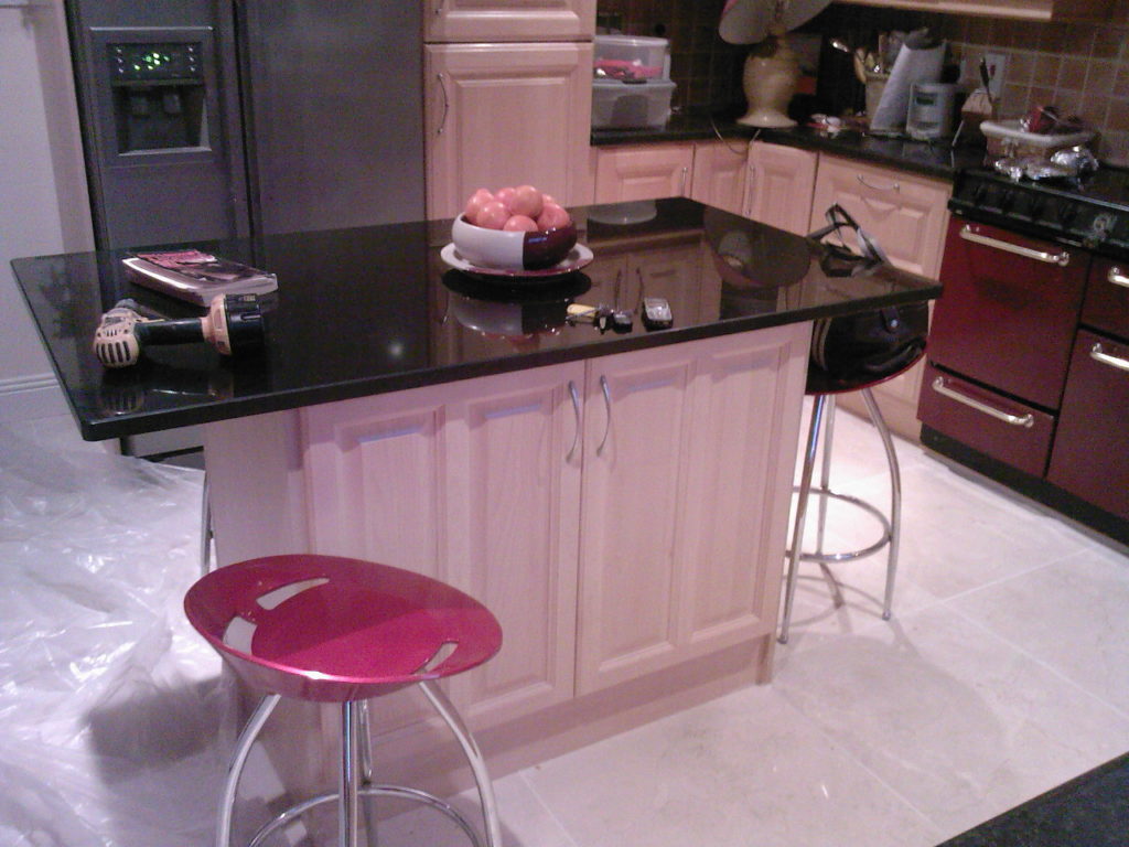 Черная столешница кухонного острова с розовыми дверками