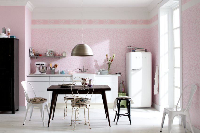 Белый холодильник на фоне розовой стены