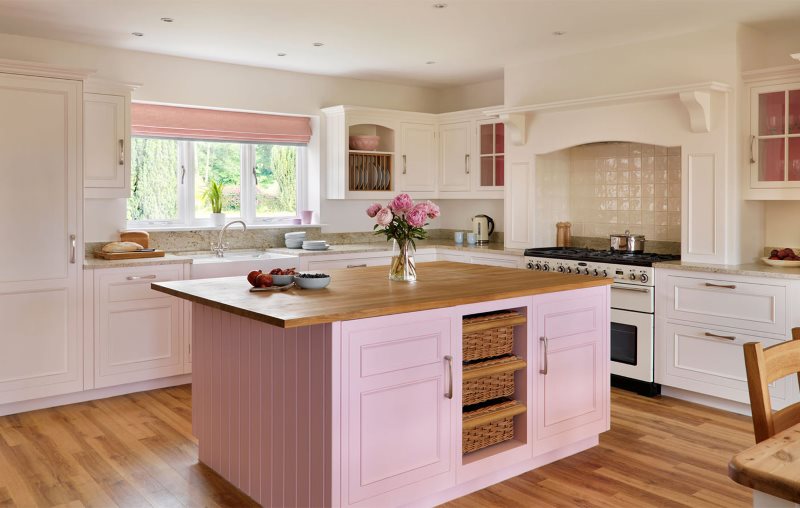 Деревянная столешница кухонного острова с розовыми фасадами