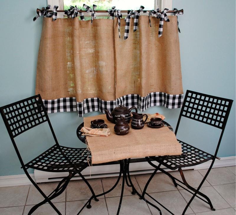 Столик для завтраков перед кухонным окном с короткой занавеской