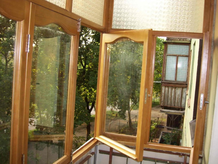 Открытые створки деревянного окна на балконе