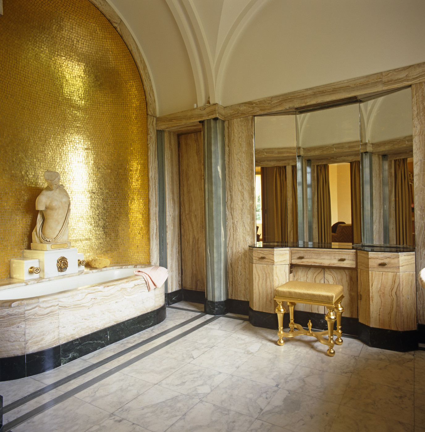 Роскошная ванная комната с золотой отделкой стены