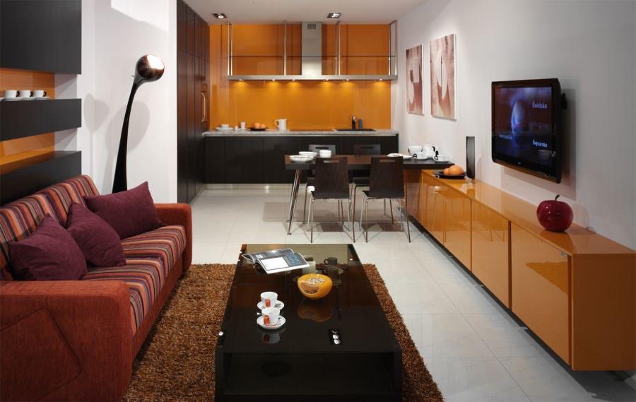 Кухня, совмещенная с гостиной, позволяет сэкономить на приобретении дополнительного телевизора, как в случаях с кухней изолированной