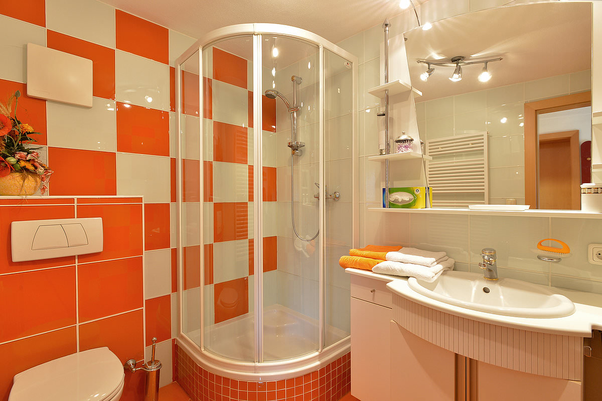 Белая сантехника в оранжевой ванной