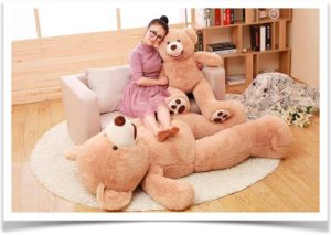 Девушка сидит на диване в обнимку с плюшевым медведем