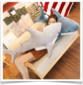Девушка спит с подушками акулами