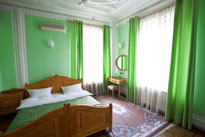 Зеленые стены и шторы в интерьере взрослой спальни